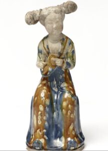 Female court figure from Tang dynasty, wearing sancai-glazed robe with elaborate hairstyle; selected by Rina Banerjee for its ornamental detail and symbolic femininity.